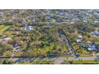 Large lot in a residential area, marked with a white border, surrounded by lush trees and greenery at 3864 Gocio Rd, Sarasota, FL 34235