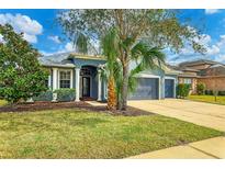 Single-story home with gray exterior, landscaping, and a two-car garage at 4360 85Th Avenue E Cir, Parrish, FL 34219