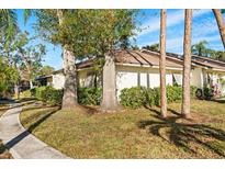 Exterior view of a light-colored house with mature trees and landscaping at 5348 Royal Palm Ave # 5348, Sarasota, FL 34234