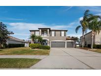 Two-story house with gray siding, three-car garage, and palm trees at 6150 42Nd Street E Cir, Bradenton, FL 34203