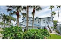 Two-story home with gray siding, metal roof, and lush landscaping at 1228 Siesta Bayside Dr # 1228-C, Sarasota, FL 34242