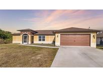 Single-story house with a brown garage door and screened porch at 1790 S Biscayne Dr, North Port, FL 34287