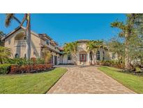Luxury home with palm trees, brick driveway, and landscaped lawn at 3365 Bayou Gate, Longboat Key, FL 34228