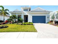 Front view of a lovely house with a blue garage door and well-manicured lawn at 8066 Redonda Loop, Bradenton, FL 34202