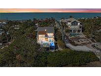 Beautiful beach house featuring palm trees and ocean views at sunset at 140 N Casey Key Rd, Osprey, FL 34229