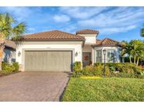 One-story home with tile roof, two-car garage, and landscaped front yard at 14608 Derna Ter, Bradenton, FL 34211