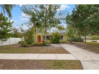 Yellow house with red door, driveway, and landscaped yard at 2202 Hyde Park St, Sarasota, FL 34239