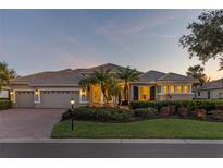 Stunning single-story home with a three-car garage and beautiful landscaping, showcasing its curb appeal at 505 Sand Crane Ct, Bradenton, FL 34212