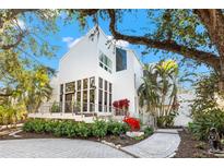 Modern white two-story home with landscaped grounds and paver driveway at 5235 Siesta Cove Dr, Sarasota, FL 34242