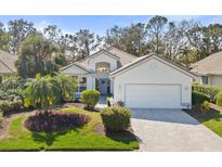 Charming home featuring a well-manicured lawn, decorative landscaping, and a welcoming two-car garage at 6416 Wentworth Xing, University Park, FL 34201