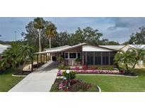 Single-story home with landscaped yard, covered porch and carport at 8520 Imperial Cir, Palmetto, FL 34221