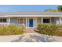 Inviting light blue home with a blue front door, rocking chairs, and well-manicured landscaping at 2329 Outer Dr, Sarasota, FL 34231