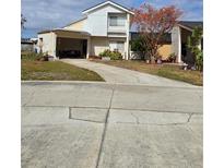 Two-story house with carport, landscaping, and paved driveway at 2566 Forest Run Ct, Clearwater, FL 33761