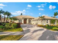 Single-story home with tile roof, two-car garage, and landscaped yard at 4941 Bridgehampton Blvd, Sarasota, FL 34238