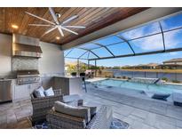 Outdoor kitchen with stainless steel appliances and pool view at 5035 Seafoam Trl, Bradenton, FL 34211