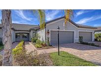 Attractive exterior of a two-story house with a gray double garage and landscaped walkway at 7590 Summerland Cv, Bradenton, FL 34202