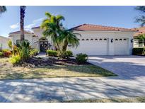 White two-story house with a three-car garage and lush landscaping at 14721 Bowfin Ter, Lakewood Ranch, FL 34202