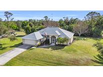 Single-story home with a large yard and driveway at 23159 Allen Ave, Punta Gorda, FL 33980