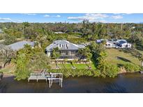 Waterfront home with a screened-in porch, private dock, and lush landscaping, perfect for enjoying the outdoors at 2500 Jamaica St, Sarasota, FL 34231
