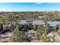 Aerial view of condo community with ocean views, lush landscaping, and tennis courts at 362 Pine Run Dr, Osprey, FL 34229