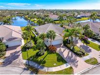 Aerial view of a house with a beautiful landscape and a lake in the background at 5551 Avellino Pl, Sarasota, FL 34238