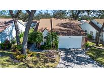 Cute single-story home with a large driveway and mature landscaping at 5807 Garden Lakes Fern # 5807, Bradenton, FL 34203