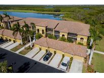 Aerial view of condo community showcasing building exterior, landscaping, and parking at 7315 River Hammock Dr # 206, Bradenton, FL 34212