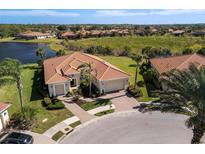 Luxury home with tile roof, driveway, and lush landscaping, offering a relaxing view of the lake and surrounding neighborhood at 110 Asti Ct, North Venice, FL 34275