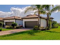 Two-car garage, brick pavers, and lush landscaping highlight this home's exterior at 12251 Myrtle Bay Ct, Sarasota, FL 34238