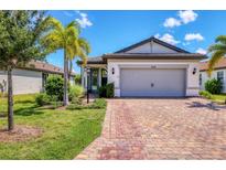 Single-story home with gray garage door and brick driveway at 17649 Northwood Pl, Bradenton, FL 34202