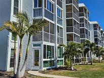 Beautiful condominium building featuring screened-in lanais and lush landscaping with mature palm trees at 4900 38Th S Way # 201, St Petersburg, FL 33711