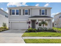 Two-story house with gray siding, gray shutters, and a two-car garage at 5307 Grove Mill Loop, Lakewood Ranch, FL 34211