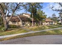 Charming home exterior with well-manicured lawn, mature trees, and a welcoming facade at 5616 Mashie Cir, North Port, FL 34287