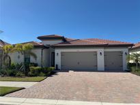 Two-story house with tan siding, brown roof, and a paved driveway at 649 Maraviya Blvd, Nokomis, FL 34275