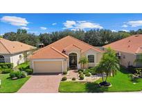 Attractive single-story home with a tile roof, landscaped yard, and brick paver driveway at 6841 74Th Street E Cir, Bradenton, FL 34203