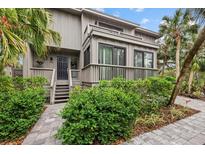 Two-story home with gray siding, multiple balconies, and lush landscaping at 1444 Landings Cir # 72, Sarasota, FL 34231