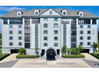 Beautiful condo building with manicured landscaping, covered entrance, and a neutral color scheme at 14820 Rue De Bayonne # 308, Clearwater, FL 33762