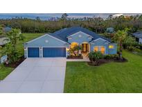 Charming single-Gathering home features a three-car garage, lush green lawn, and mature palm trees at 16307 29Th E Ct, Parrish, FL 34219