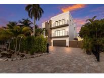 Two-story modern home with a dark brown garage door and landscaped front yard at 201 N Harbor Dr, Holmes Beach, FL 34217