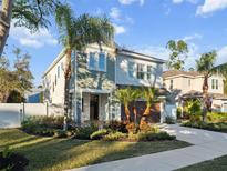 Two-story house with green siding, brown garage door, and palm trees at 2511 Prospect St, Sarasota, FL 34239