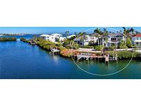 Waterfront property with private dock, lush landscaping, and tranquil water views, creating a serene outdoor space at 3580 Fair Oaks Ln, Longboat Key, FL 34228