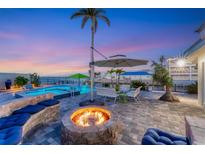Expansive patio with firepit, pool, and seating area at sunset at 3611 99Th W St, Bradenton, FL 34210