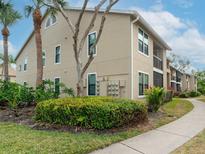 Tan building exterior with lush landscaping and walkways at 4001 Crockers Lake Blvd # 11, Sarasota, FL 34238