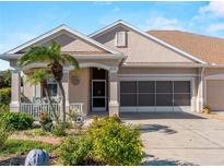 Tan house with a two-car garage and nicely landscaped yard at 4153 Lenox Blvd, Venice, FL 34293