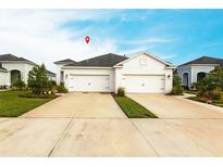 A well-maintained home featuring a two-car garage, well-manicured landscaping, and a long driveway at 4739 Willow Bend Ave, Parrish, FL 34219