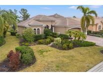 Luxury home with tile roof, manicured landscaping, and palm trees at 7033 Brier Creek Ct, Lakewood Ranch, FL 34202