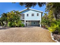 Charming light blue beach cottage with a spacious driveway at 730 Holly Rd, Anna Maria, FL 34216