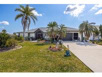 Landscaped front yard with mature palm trees and well-manicured lawn at 949 Chevy Chase St, Port Charlotte, FL 33948