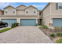 Townhouse exterior featuring a two-car garage and landscaped front yard at 11630 Woodleaf Dr, Bradenton, FL 34211