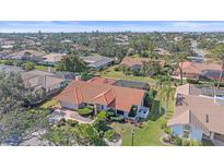 An aerial view of a home with a red tile roof, a screened-in pool, and lush landscaping at 1426 Landview Ln, Osprey, FL 34229